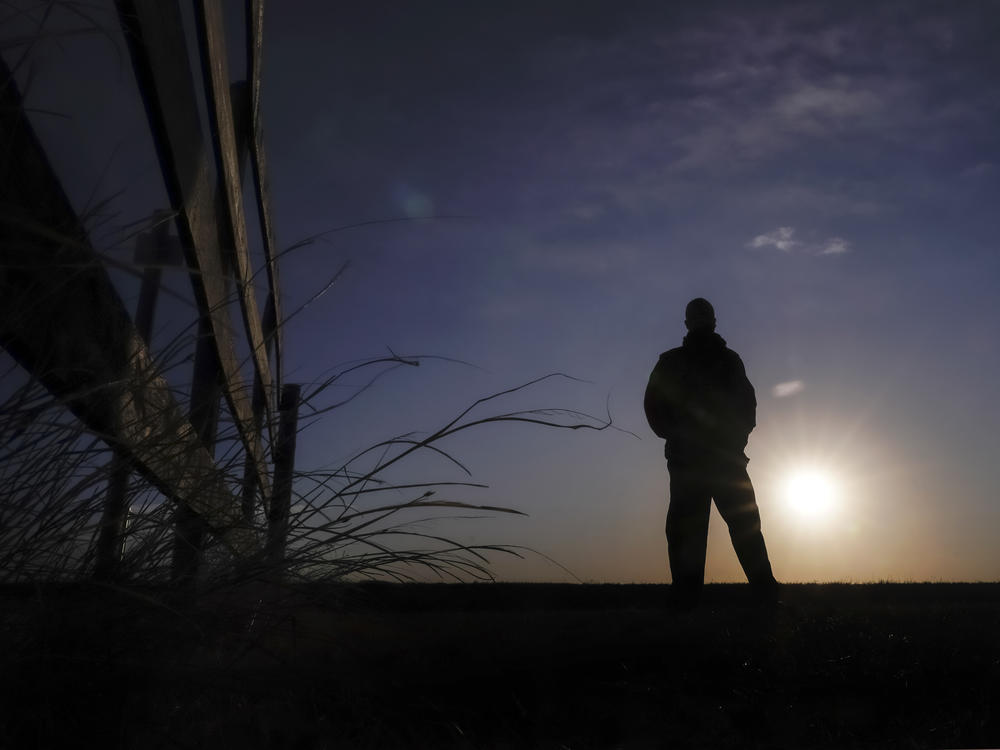 Lateef Dowdell watches the sunrise on Jan. 14, 2021, from what remains of land once belonging to his uncle Gil Alexander, who was the last active Black farmer in the community of Nicodemus, Kan.