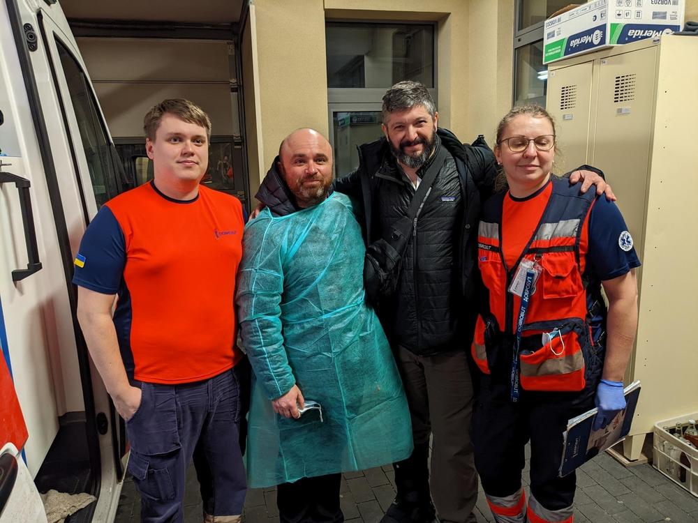 Alex Spektor (second from left) with Bryan Stern (second from right), with two of the people who helped transport the twins, shortly after they arrived in Poland in March 2022.