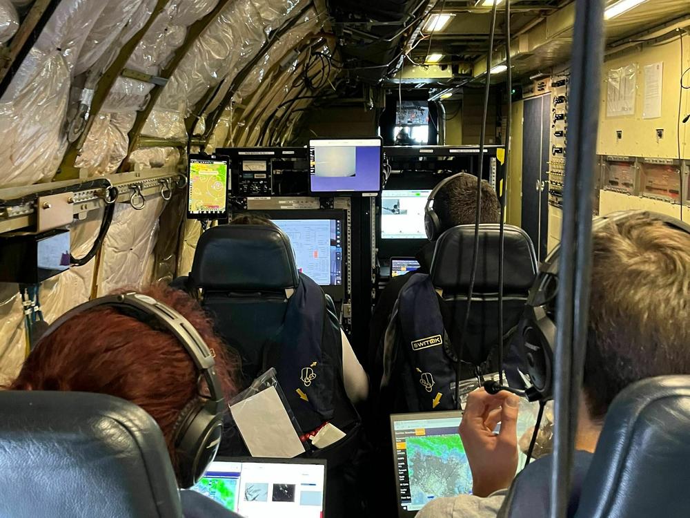 IMPACTS mission researchers inside the research plane, monitoring weather data being collected by onboard instruments.