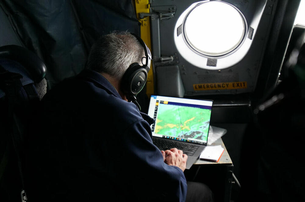 A scientist sits in the cockpit and helps coordinate a flight plan through 