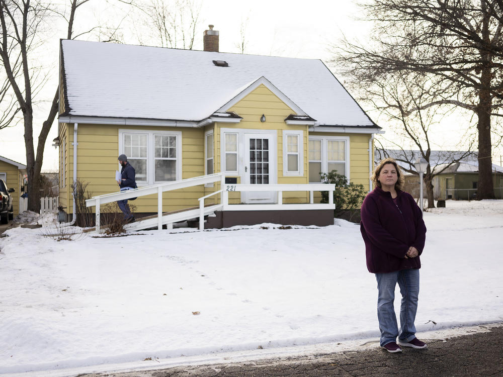 Jen Coghlan outside the home where she grew up in Perry, Iowa. Her father, Henry Ruhl, plans to leave the house to her, but Coghlan expects she'll have to sell it after he dies to settle a $226,611 from Medicaid for the care of her mother, who died in 2022. Coghlan says the family didn't realize that her mother was on Medicaid.