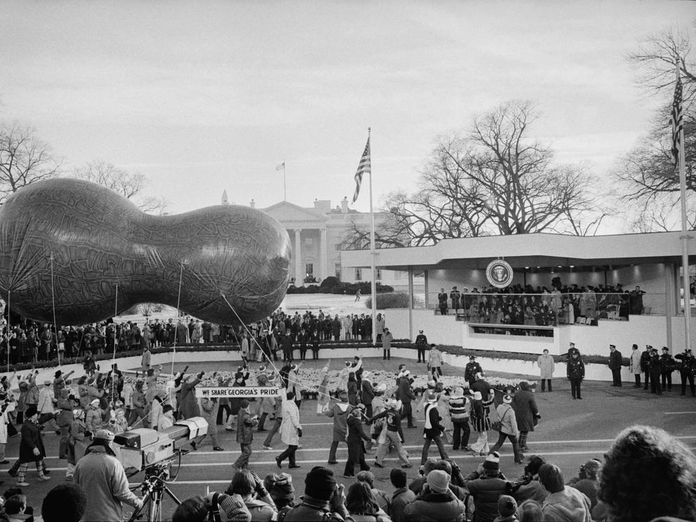 A peanut-shaped float passes by the Presidential reviewing stand for the inauguration of Jimmy Carter in Washington, D.C. on January 20, 1977. The stand, instead of being sent to a landfill, was recycled and sent to Atlanta where it was used as a band stand for free public concerts.