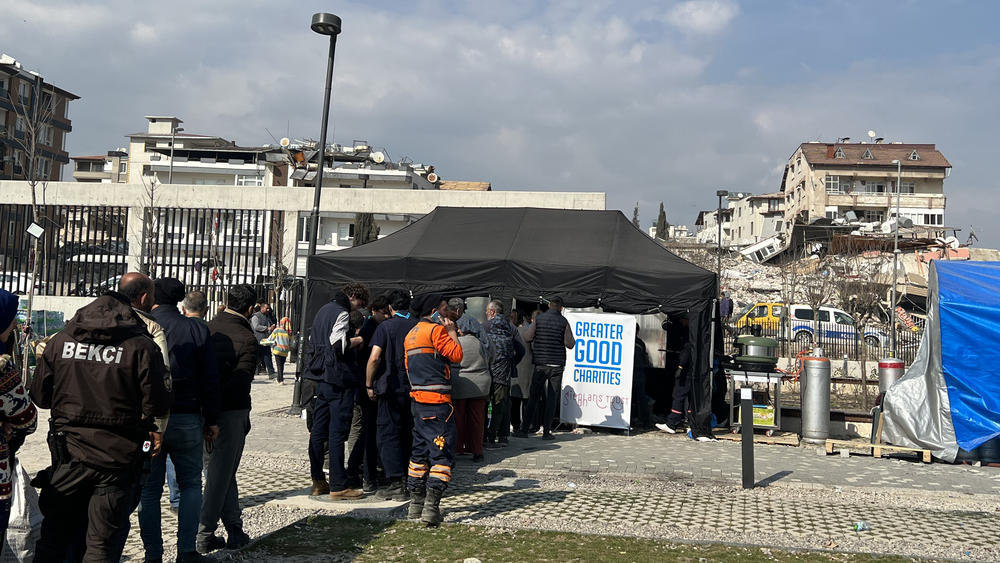 People displaced by the earthquake line up for food at a tent city in Antakya, in Turkey's central Hatay Province.