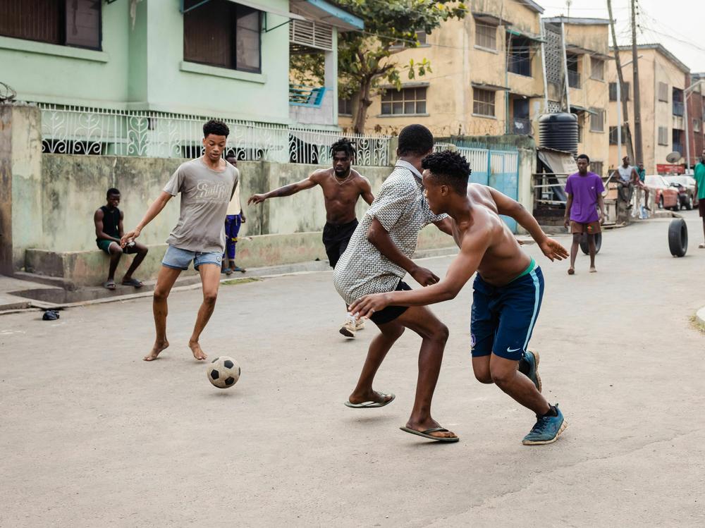 Youth play football on the streets before going to the polling unit at Ojuelegba in Lagos on February 25, 2023, during Nigeria's presidential and general election.
