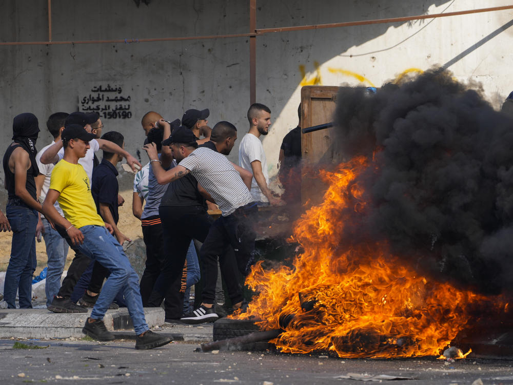 Palestinian demonstrators clash with the Israeli army while forces carry out an operation in the West Bank town of Nablus, on Aug. 9, 2022.