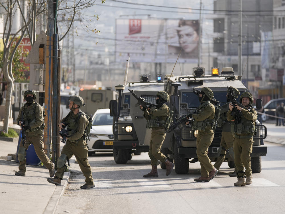 Israeli soldiers take up positions at the scene of a Palestinian shooting attack at the Hawara checkpoint, near the West Bank city of Nablus, on Sunday.