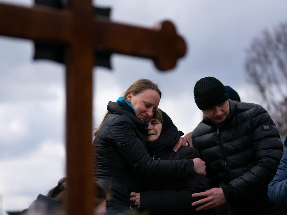 Ukrainian journalist-turned-soldier Viktor Dudar's mother (center) grieves at his grave as he's laid to rest in Lviv, Ukraine, last March. Last week the world marked the first anniversary of Russia's large-scale invasion of Ukraine.