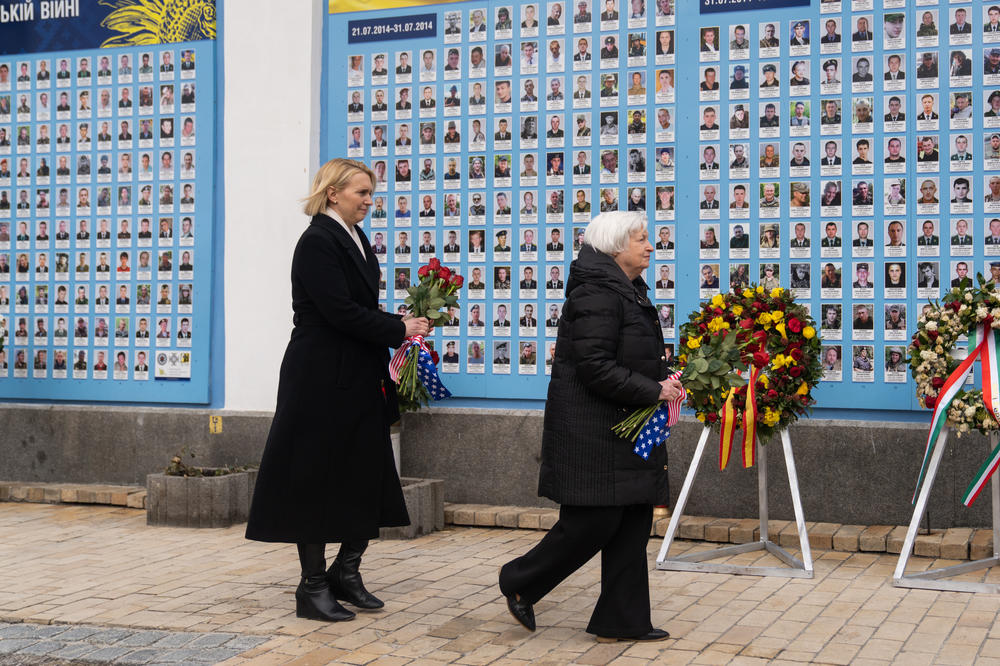 Treasury Secretary Janet Yellen walks to lay flowers at a wall of remembrance in Kyiv Monday.