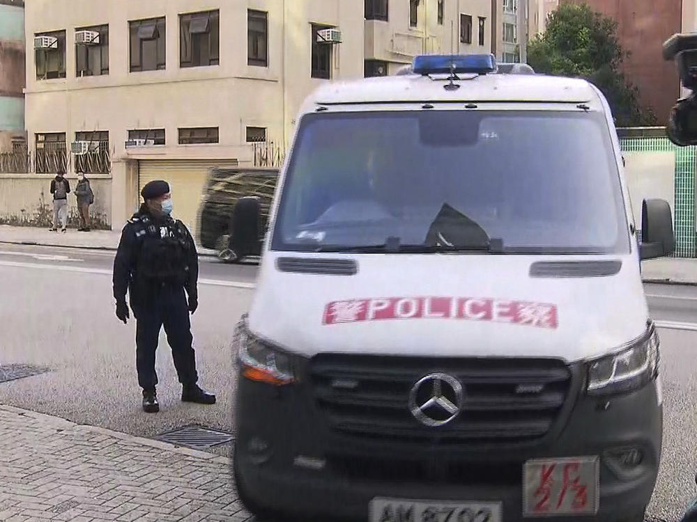 In this image taken from video footage run by TVB Hong Kong, journalists film a police van believed to be carrying relatives of murdered model Abby Choi on its arrival at the Kowloon City Law Courts Building in Hong Kong, Monday, Feb. 27, 2023.