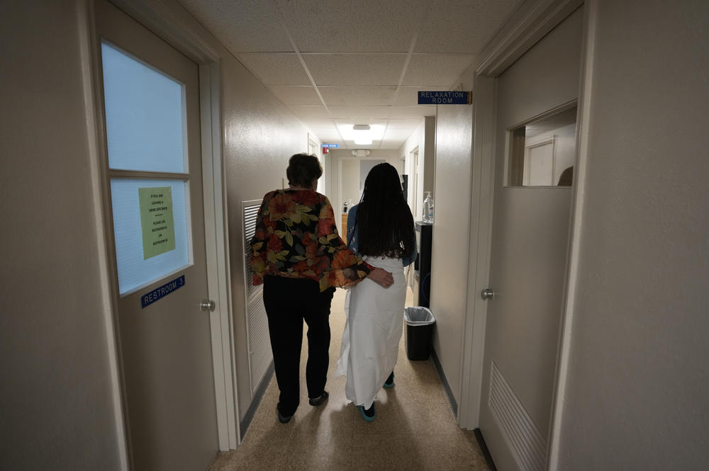 A 33-year-old mother of three from central Texas is escorted down the hall by a clinic administrator prior to getting an abortion, at Hope Medical Group for Women in Shreveport, La., in late 2021. More than a dozen patients, mostly from Texas, arrived at the abortion clinic in Louisiana.