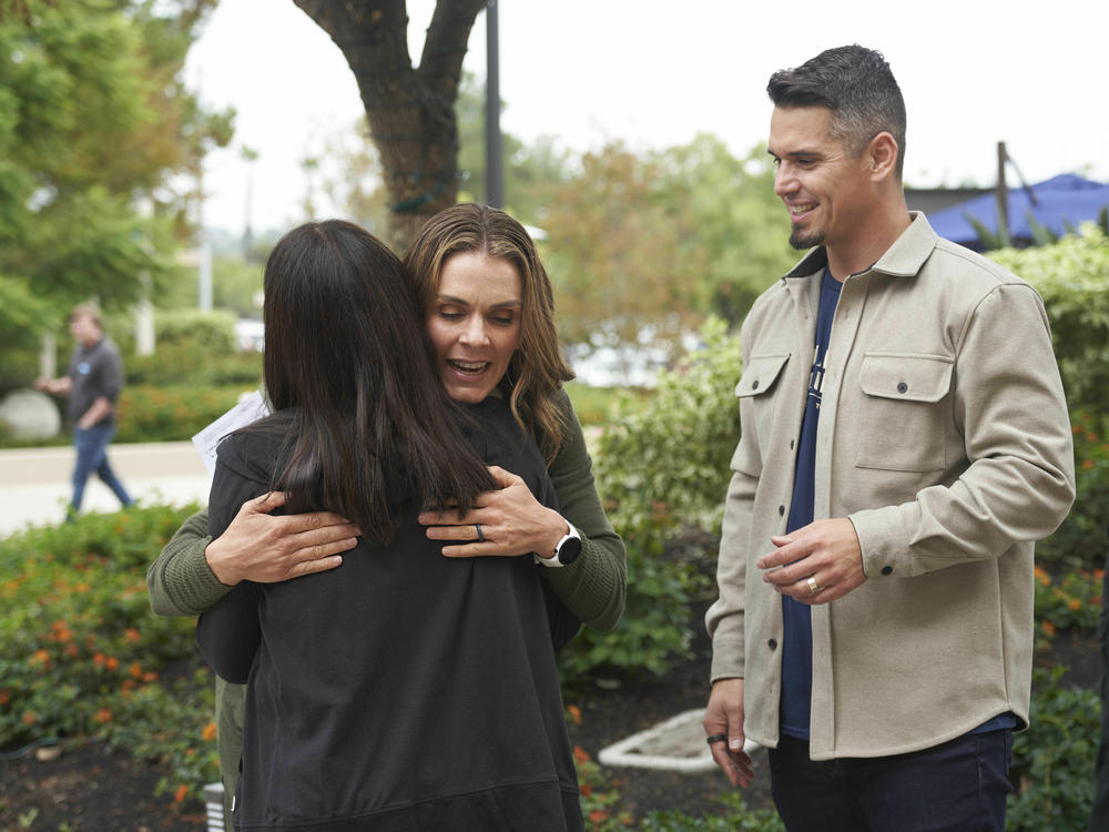 Pastor Andy Wood (right) and his wife, Stacie Wood, meet with a congregant on Oct. 16, 2022, at Saddleback Church in Lake Forest, Calif. Stacie Wood was listed as a teaching pastor for the church, which was ousted from the Southern Baptist Convention over female leadership.