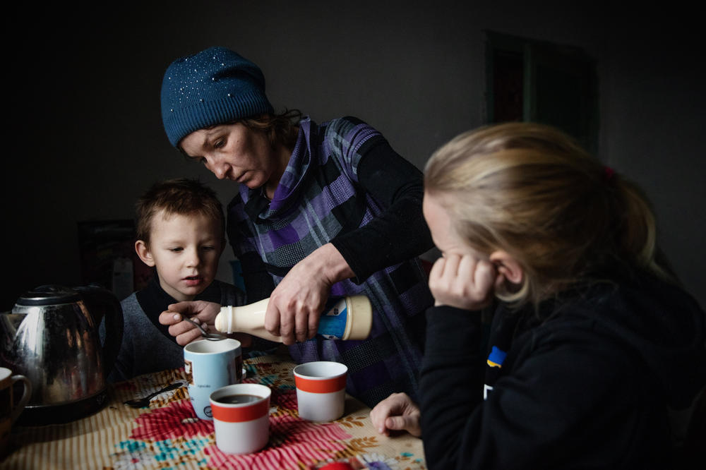 Olga Grinik with her son Kirill, 5, and daughter Miroslava, 8, in the kitchen of their new house in Poltava region. December 2022.