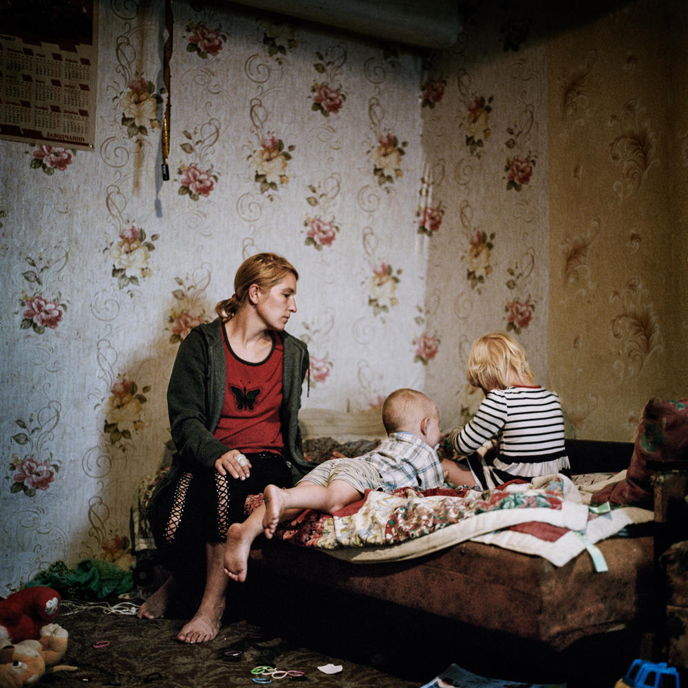 Olga Grinik and her children at their old home in Avdiivka, Donetsk region, which they recently learned has been destroyed. July 2019.
