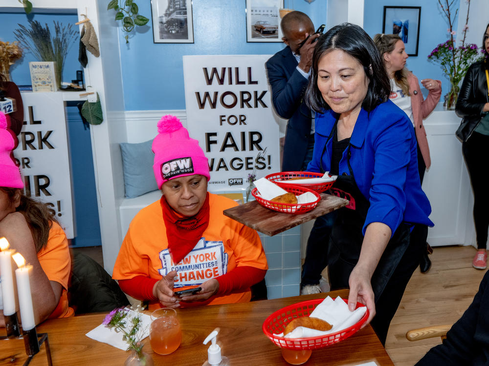 Deputy Labor Secretary Julie Su serves food as she is trained to serve tables during a Learn About Worker Experiences event at the Skal restaurant in Brooklyn on April 11, 2022.