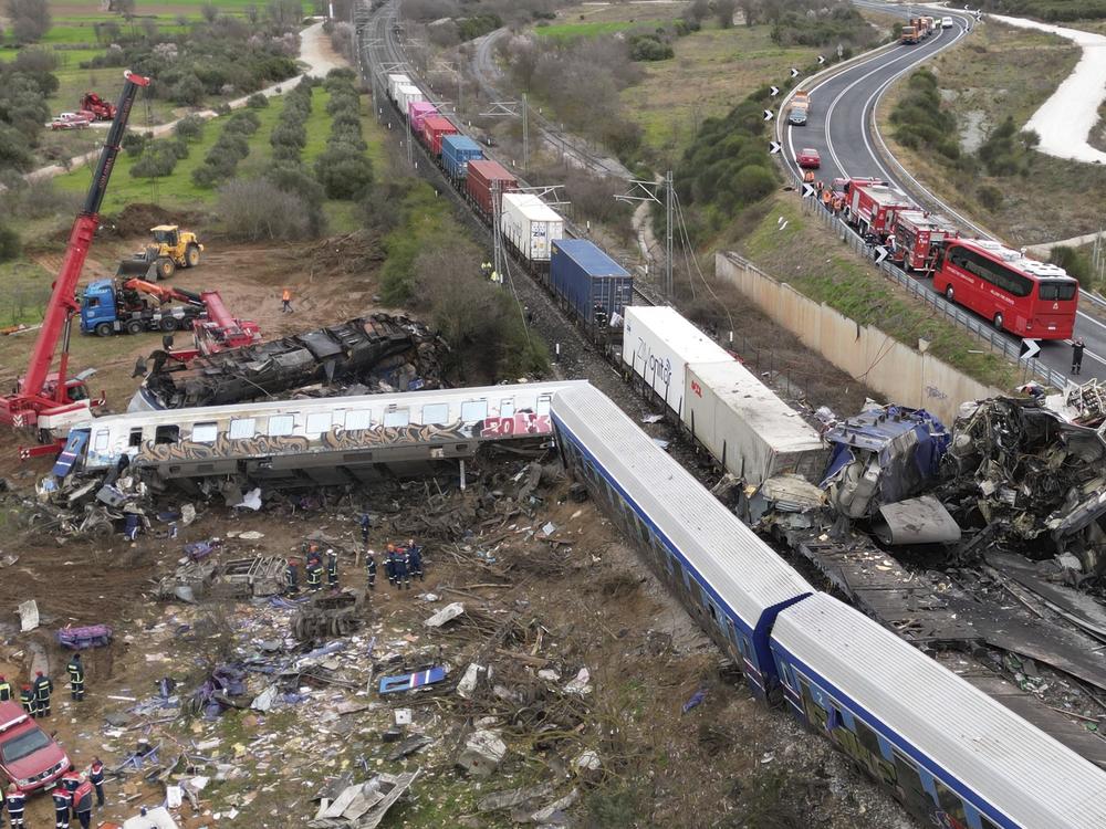 A crane, firefighters and rescuers operate after a collision in Tempe near Larissa city, Greece, Wednesday, March 1, 2023.