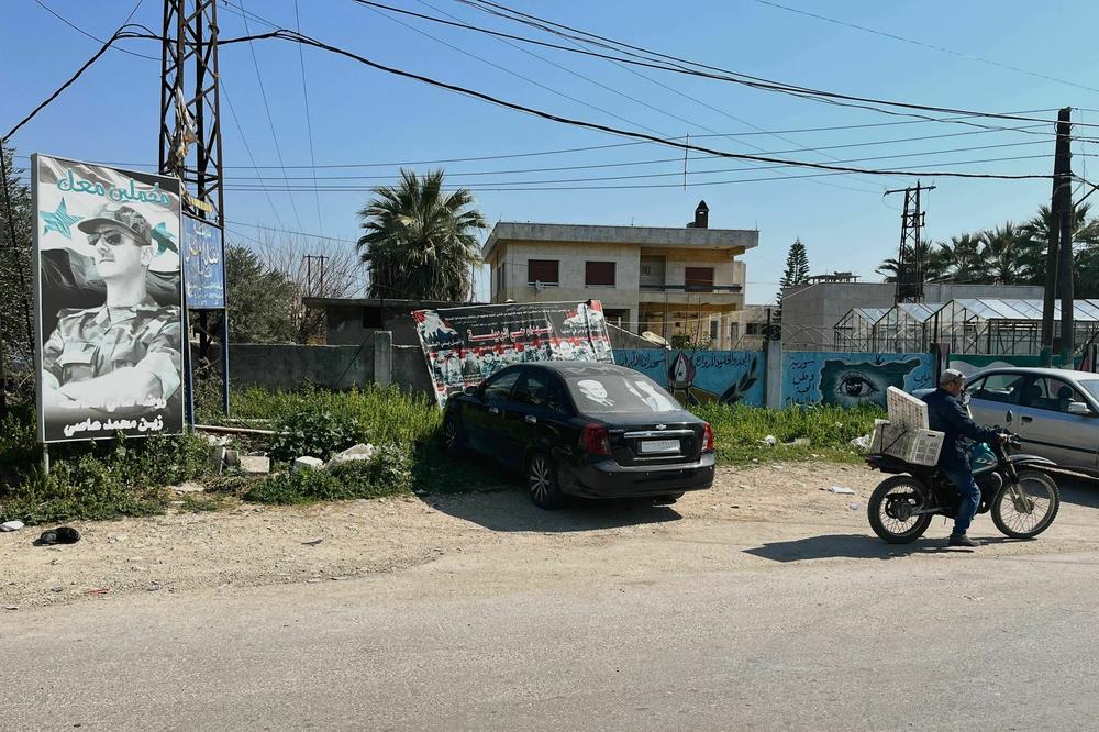 This image shows a poster of Syria's president under the slogan 