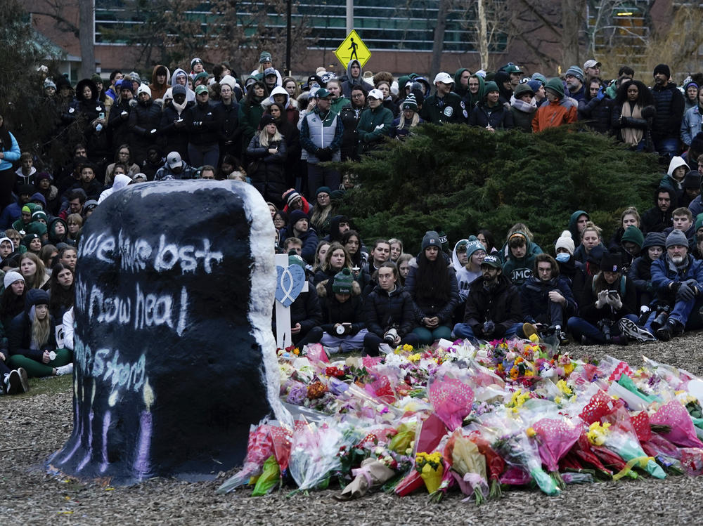 Mourners sit at The Rock on the grounds of Michigan State University in East Lansing, Mich., Wednesday, Feb. 15, 2023. Alexandria Verner, Brian Fraser and Arielle Anderson were killed and several other students remain in critical condition after a gunman opened fire on the campus of Michigan State University Monday night.
