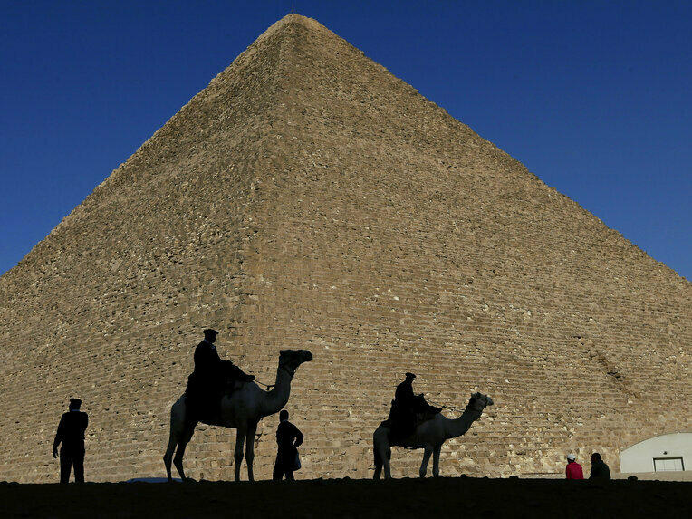 Policemen are silhouetted against the Great Pyramid in Giza, Egypt, in 2012.