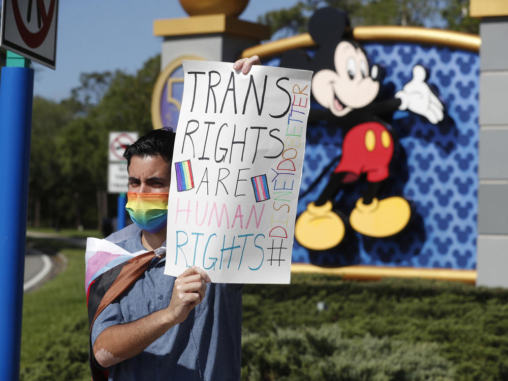Disney employee Nicholas Maldonado holds a sign while protesting outside Walt Disney World on March 22, 2022. After initial hesitation, Disney opposed controversial Florida legislation known as the 