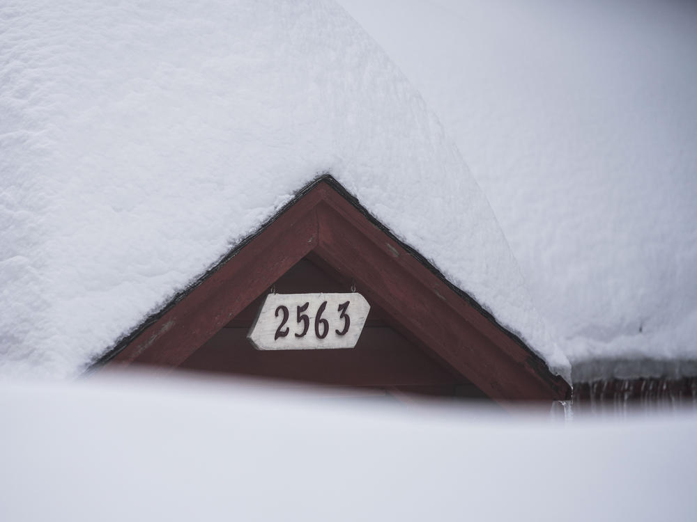 Snow is piled up on a home in Running Springs, Calif., on Feb. 28, 2023. Mountainous areas of California experienced nearly unprecedented snowfall accumulations — more than 40 feet since the start of the season.