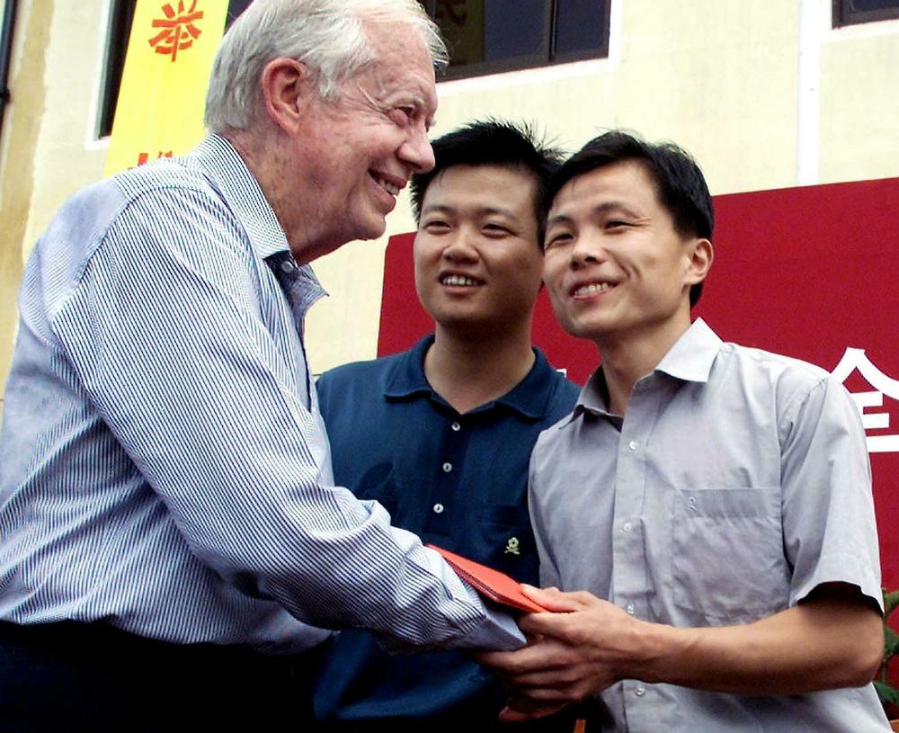 September 5, 2001: This file photo shows former US president Jimmy Carter (L) greeting newly elected local officials at the village of Quanwang in Zhouzhuang town. Carter had urged China to hold direct democratic elections at township and county levels and vowed to bring up the issue with Chinese President Jiang Zemin.