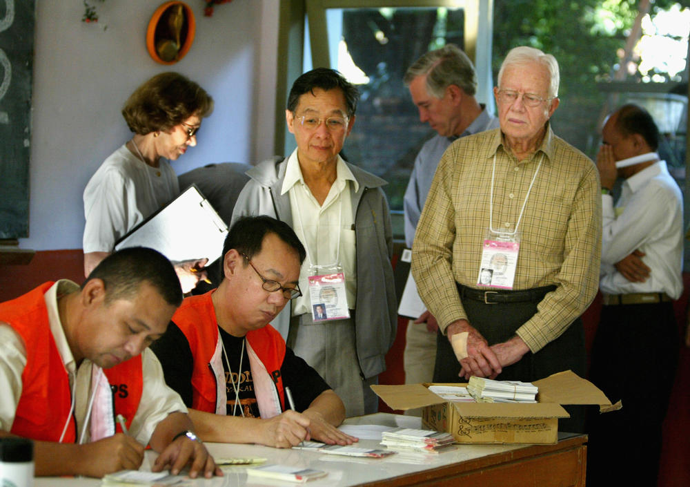 July 5, 2004: Former U.S. President Jimmy Carter (R) watches election workers during a visit to a polling station on July 5,2004. Carter is in the country assisting election observers from the Carter center as well as observing the election process. Indonesians voted today to choose a candidate for the first time over a party. (Photo by Paula Bronstein/Getty Images)