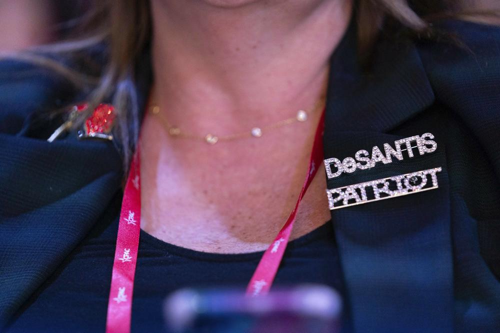 A woman attending CPAC wears a DeSantis pin on Thursday.