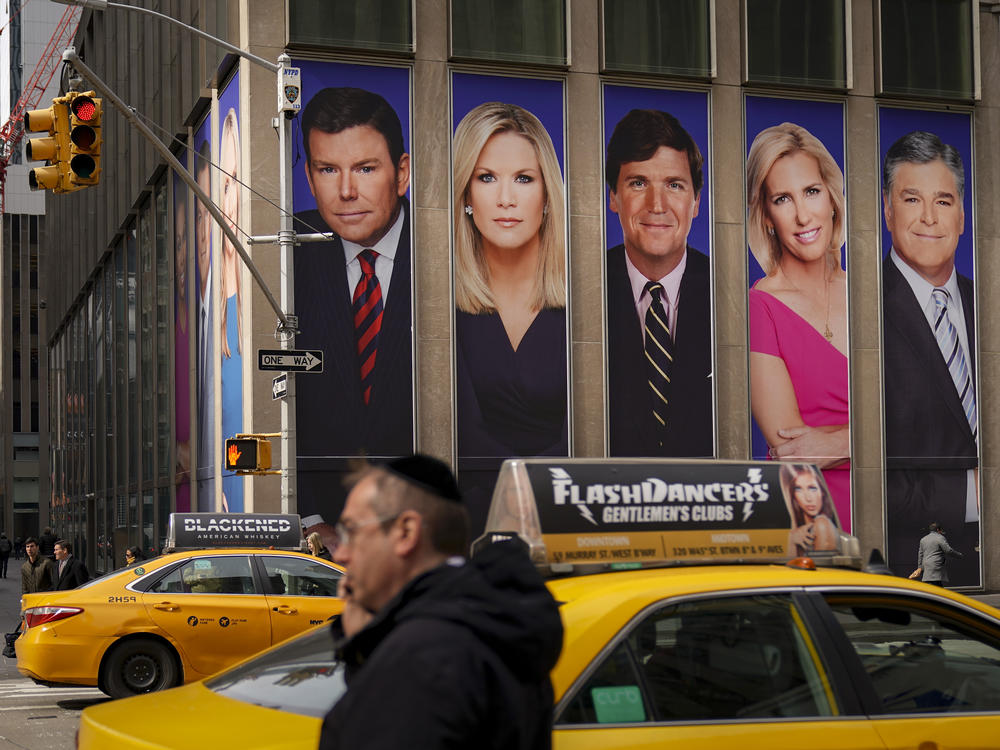 Posters bearing the images of Bret Baier, Martha MacCallum, Tucker Carlson, Laura Ingraham and Sean Hannity, from left, adorn the front of Fox Corp.'s headquarters in New York City. The stars' panic as viewers fled after the 2020 elections has become a core element of a $1.6 billion defamation suit against Fox.