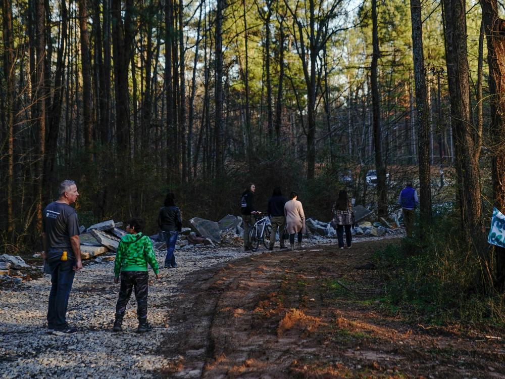 Family members of environmental activist Manuel Esteban Paez Terán visit a makeshift memorial for Terán on Feb. 6 at the site of the proposed police training facility.