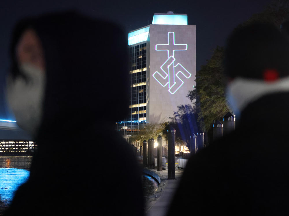 Members of the white nationalist group National Socialist Florida use a laser projector to display white nationalist and anti-LGBTQ images on the side of the CSX building and other high-rise buildings in Jacksonville, Fla.