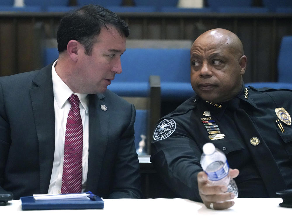 Mississippi Public Safety Commissioner Sean Tindell, left, confers with Jackson Police Chief James Davis during a town hall meeting to address youth crime issues in Jackson, Miss., Feb. 14, 2023.