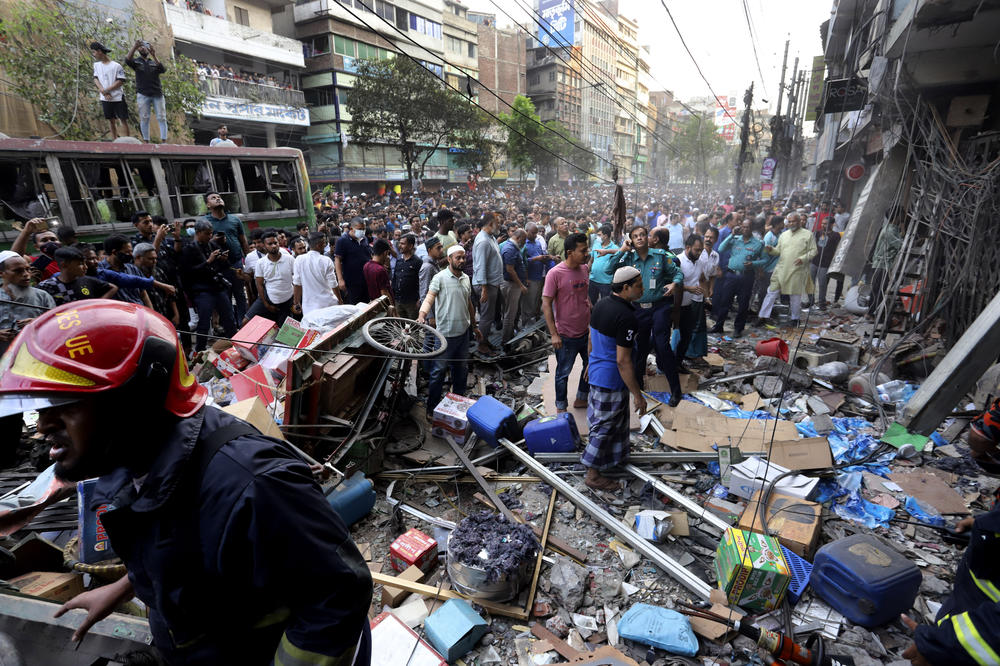Onlookers gather outside the site of the explosion at a commercial building in Dhaka, Bangladesh, Tuesday.