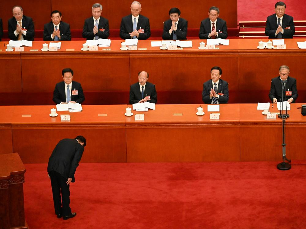Chinese State Councilor and Secretary-General of the State Council Xiao Jie bows to delegates before delivering a speech during the second plenary session of the National People's Congress at the Great Hall of the People in Beijing on Tuesday.