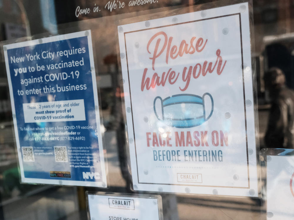 New York no longer has a face mask mandate — and New York City Mayor Eric Adams is telling stores to get customers to lower their mask before entering, to help prevent crime. It's a reversal of previous guidance for shops: Here, a face mask sign is seen on a cafe's door in December of 2021, when the state mandated the wearing of masks.