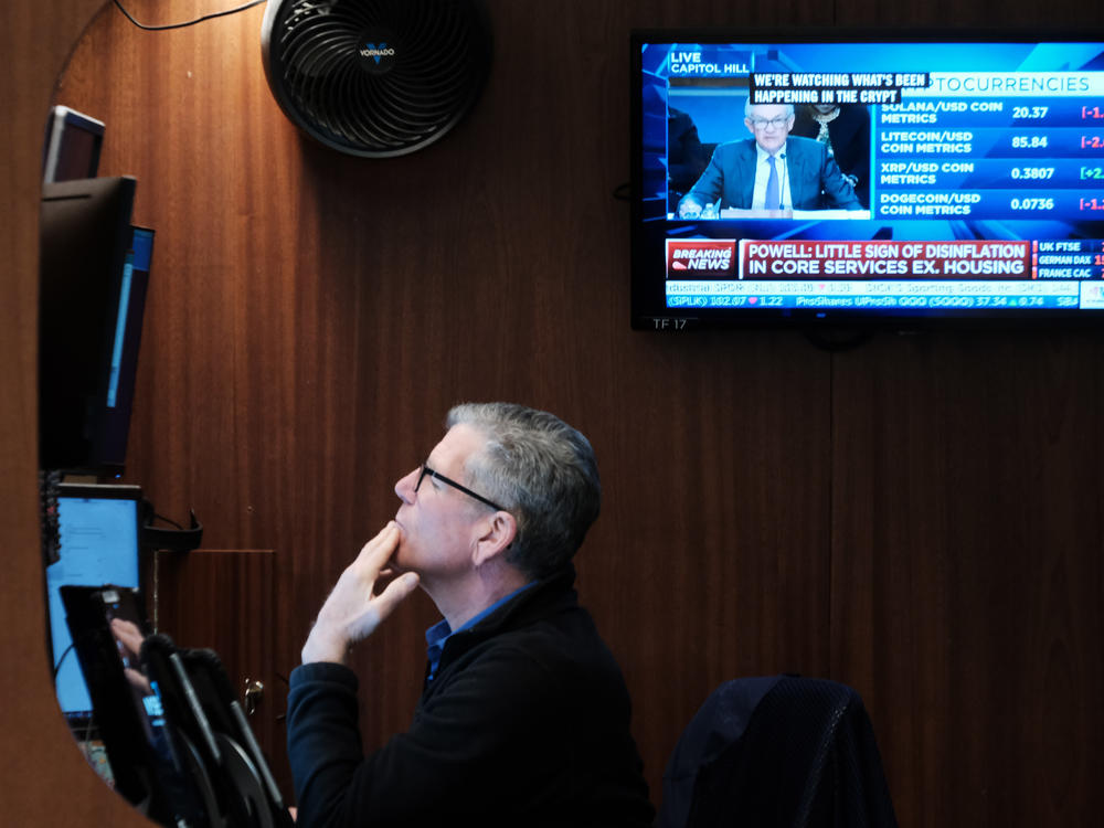 Traders work on the floor of the New York Stock Exchange (NYSE) in New York City as Powell testifies before the Senate Banking Committee on Tuesday. Stocks tumbled after Powell suggested the Fed may need to raise interest rates more aggressively to bring down inflation.