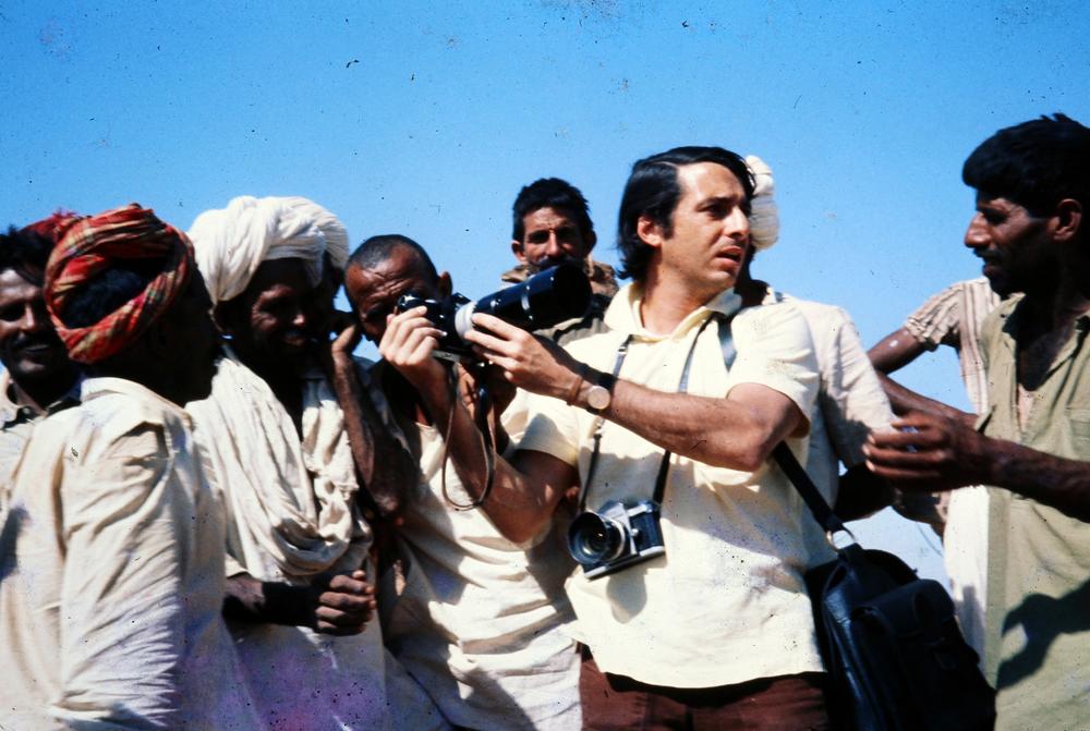 Lewis M. Simons at work for the <em>Washington Post</em> in India in 1974, demonstrating a telephoto lens to some of the 200,000 participants at the annual Pushkar Fair in Rajasthan state.