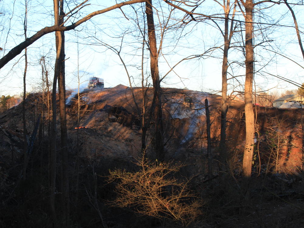 A truck sprays water on part of the burning landfill during the EPA's work to smother the site in dirt.