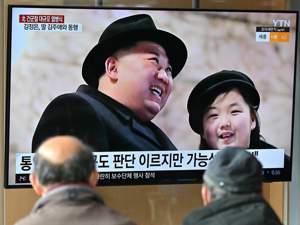 People watch a television screen showing a news broadcast with an image of North Korean leader Kim Jong Un, left, and his daughter presumed to be named Ju Ae attending a military parade held in Pyongyang to mark the 75th founding anniversary of its armed forces, at a railway station in Seoul on Feb. 9, 2023.