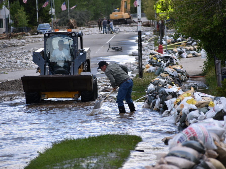 Residents of Red Lodge, Mont., are seen clearing mud, water and debris from the small city's main street after flood waters coursed through a residential area with hundreds of homes.