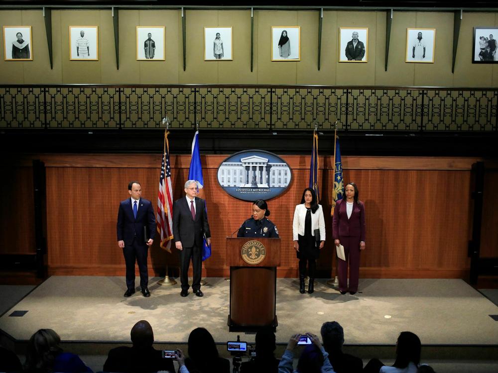 Louisville Metro Police Department Interim Chief Jacquelyn Gwinn-Villaroel, along with other city and federal officials, discuss the civil rights investigation at a press conference on Wednesday. Louisville Mayor Craig Greenberg (L) and U.S. Attorney General Merrick Garland (R) are standing to her left.