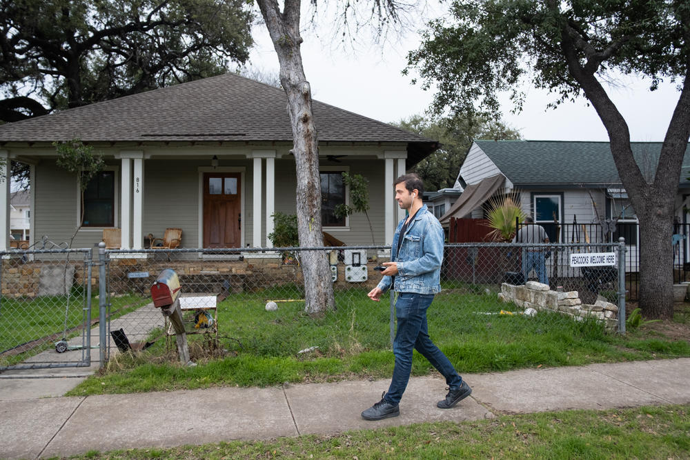 John Liss takes a work phone call as he walks through his neighborhood in South Austin, Texas. His appraisal company is experimenting with artificial intelligence to counter the impact of redlining.