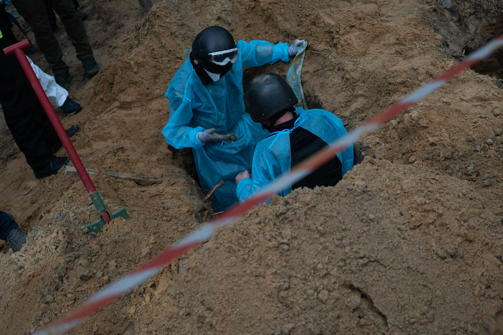 Ukrainian investigators exhume bodies from a mass grave site in Izium in September. Investigators were hoping to find and document possible evidence of war crimes, and also to be able to identify those buried here without a name.
