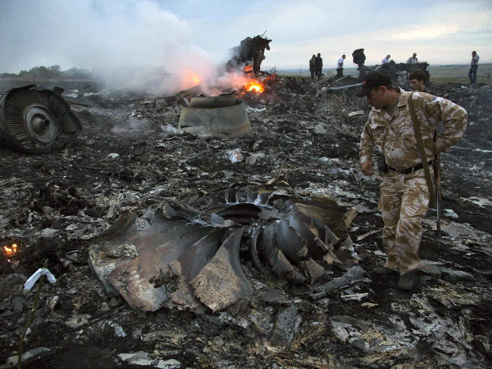 People walk amid the debris at the crash site of the Flight MH17 passenger plane near the village of Grabovo, Ukraine, on July 17, 2014.