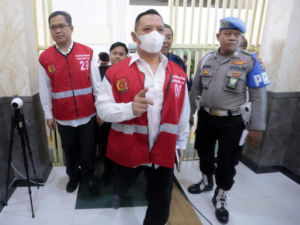 Arema FC Organizing Committee chair Abdul Haris, left, the club's security chief Suko Sutrisno, center, walk to the courtroom to attend their sentencing hearing at a district court in Surabaya, East Java, Indonesia, Thursday, March 9, 2023.
