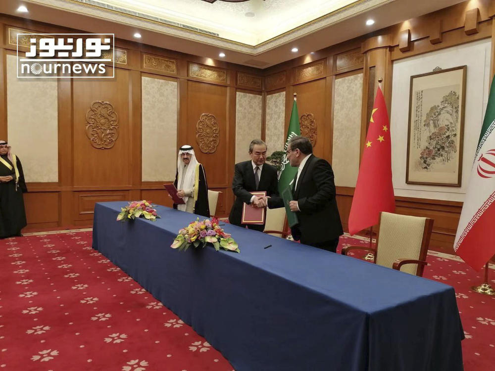 Secretary of Iran's Supreme National Security Council Ali Shamkhani (right) shakes hands with senior Chinese diplomat Wang Yi, as Saudi national security adviser Musaad bin Mohammed al-Aiban looks on during an agreement signing ceremony between Iran and Saudi Arabia to reestablish diplomatic relations and reopen embassies in Beijing, Friday.