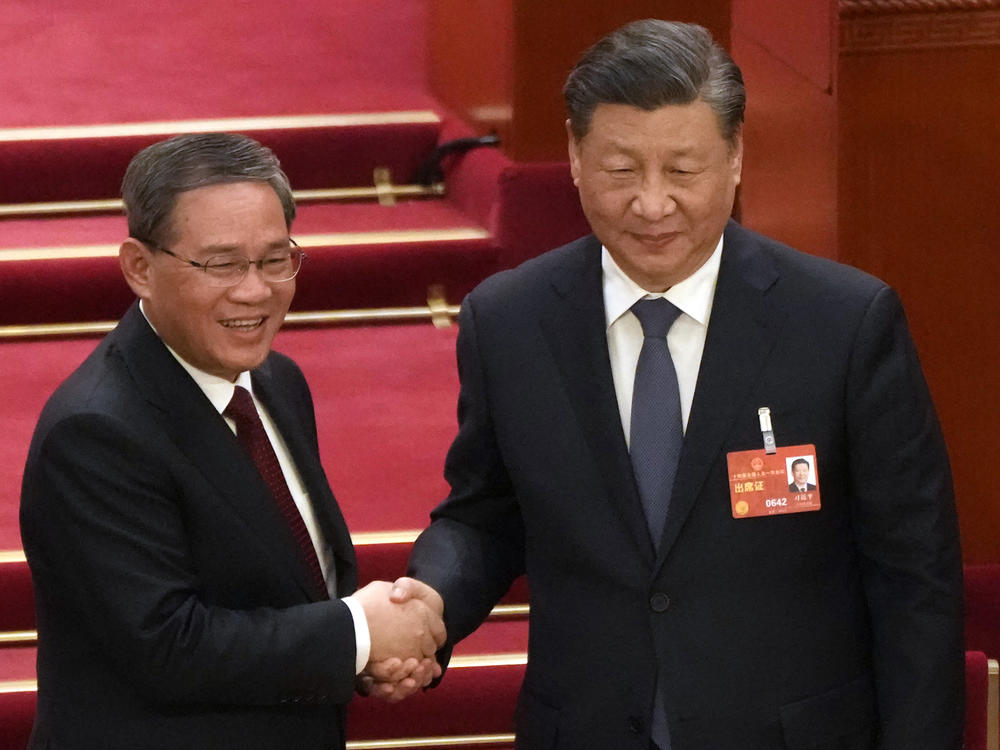 Newly elected Premier Li Qiang, left, shakes hands with Chinese President Xi Jinping during a session of China's National People's Congress in Beijing on Saturday.