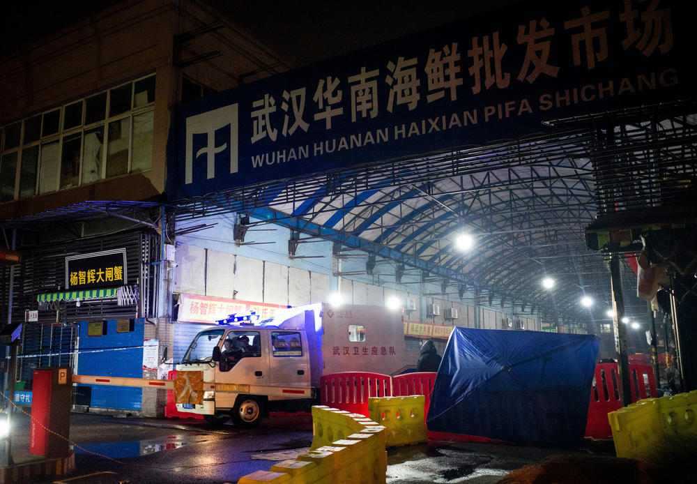 Staff of the Wuhan Hygiene Emergency Response Team leave the shuttered Huanan Seafood Wholesale Market in Wuhan on Jan. 11, 2020. There is strong evidence that the COVID-19 pandemic originated in animals at this market. China stated that a 61-year-old man who purchased goods there was the first known death from the respiratory illness caused by the new coronavirus.