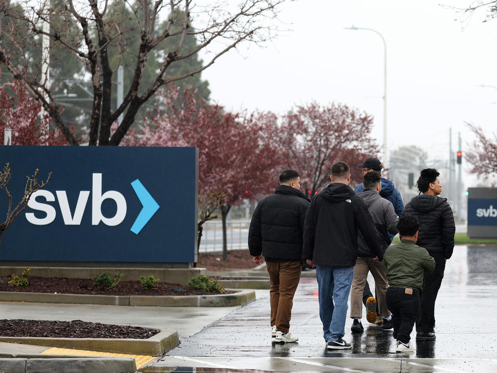 People walk through the parking lot at the Silicon Valley Bank headquarters in Santa Clara, Calif., on March 10, 2023. The bank suffered a run on deposits that led to its collapse.