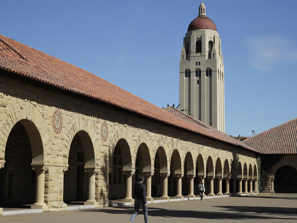 People walk on the Stanford University campus beneath Hoover Tower in Stanford, Calif., on March 14, 2019. Stanford University says it is investigating after multiple swastikas and an image of Adolf Hitler were found on a door Saturday at a Stanford student residence hall.