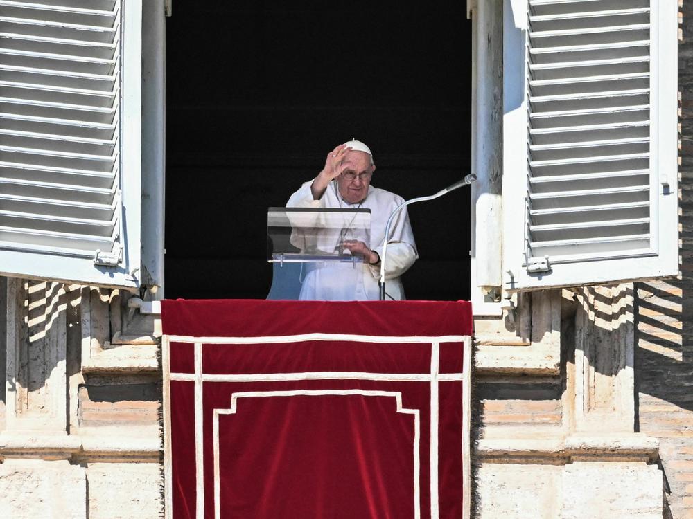 Pope Francis waves from the window of the apostolic palace during the weekly Angelus prayer on Sunday in the Vatican.